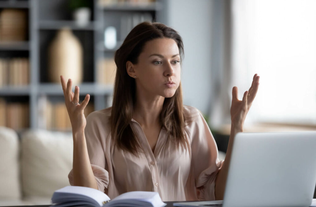 Young woman being easily frustrated by work because of not having enough sleep.