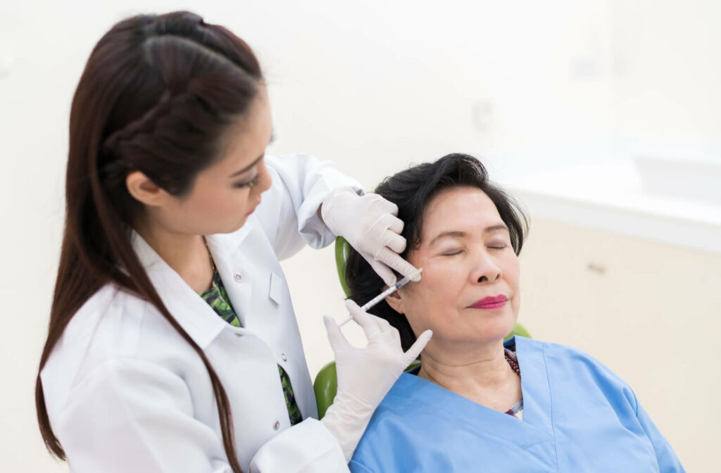 A mature woman receiving Botox from her dentist.