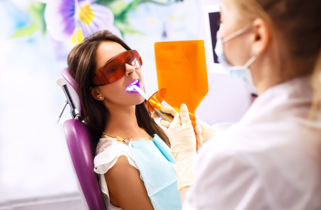 A woman receiving a laser dental treatment from a female dentist