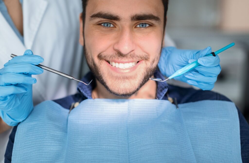 A close up of a handsome young man getting a dental exam.