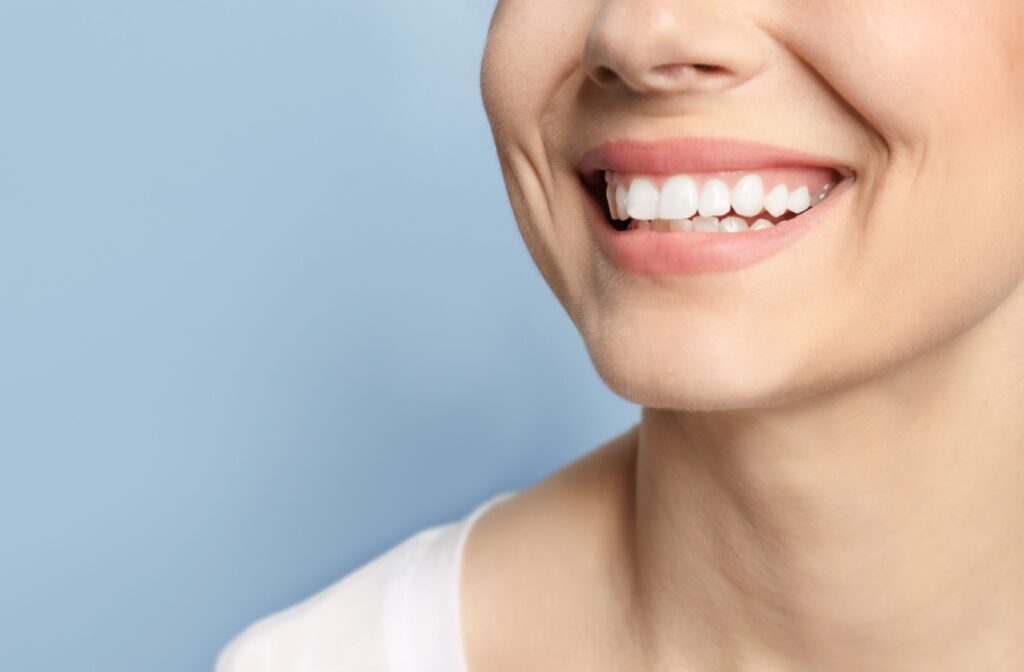 Close up photo of a person smiling on a grey background.