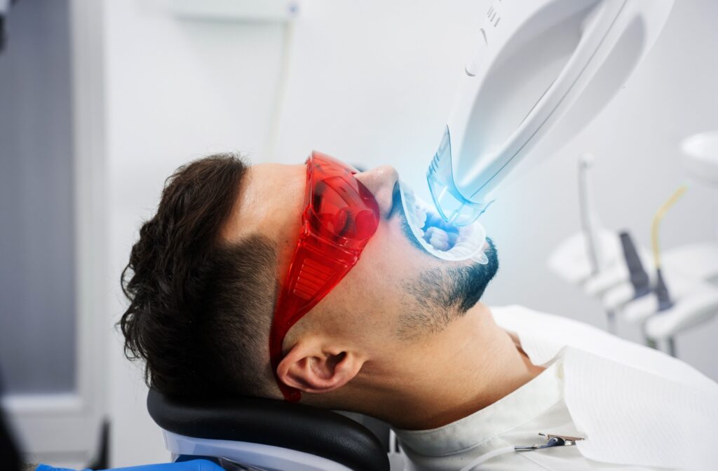 An adult undergoing an in-office professional teeth whitening procedure.