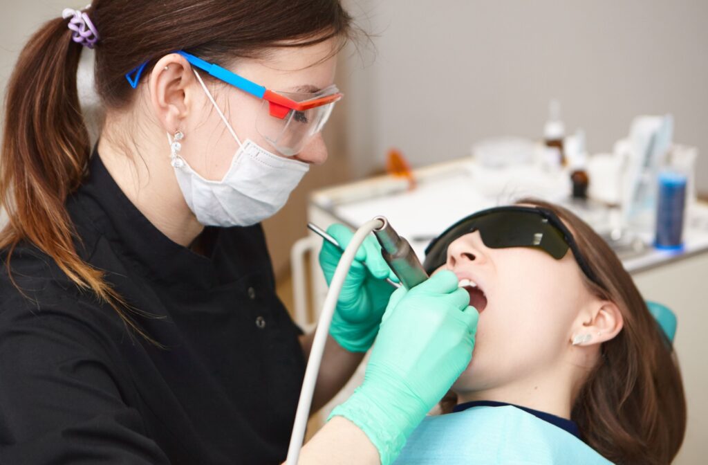 Dental professional polishing a patient's teeth during a dental hygiene visit.