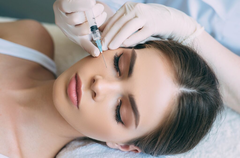 Birdseye view of a person laying down while receiving an injectable to their cheek