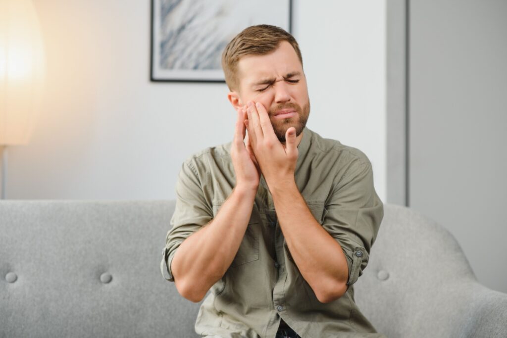 A man clutching his jaw in pain